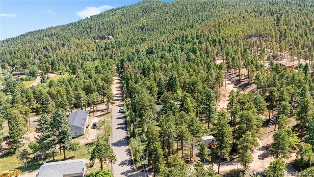 drone / aerial view featuring a wooded view