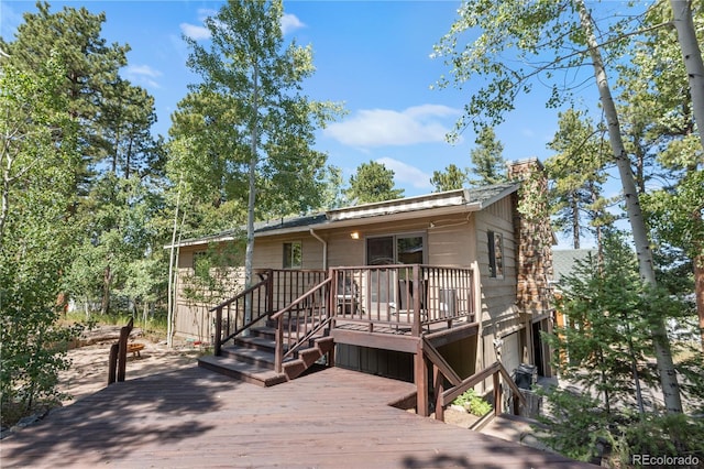 view of front of property featuring a chimney and a wooden deck