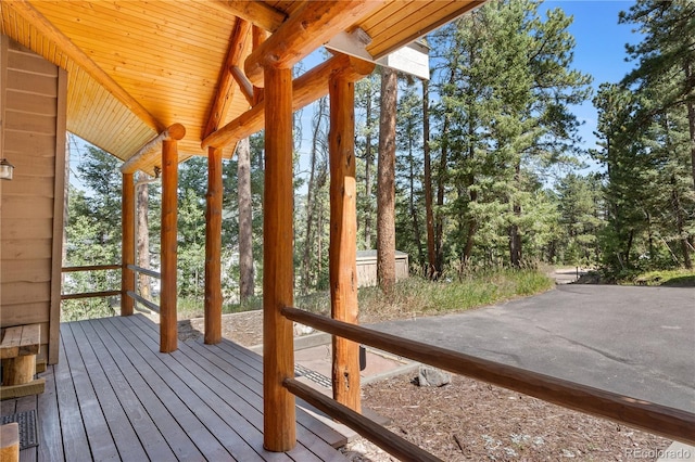 unfurnished sunroom with vaulted ceiling with beams, wood ceiling, and a healthy amount of sunlight