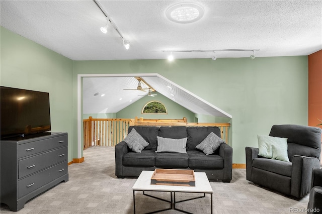 living area featuring a textured ceiling, light carpet, baseboards, vaulted ceiling, and rail lighting