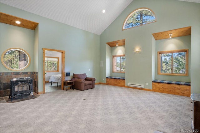 sitting room featuring baseboard heating, a wood stove, carpet flooring, high vaulted ceiling, and baseboards