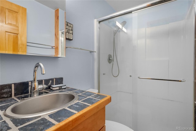 bathroom with a stall shower, vanity, and toilet