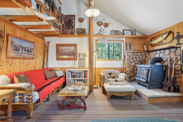 interior space with lofted ceiling, a wood stove, and wooden walls