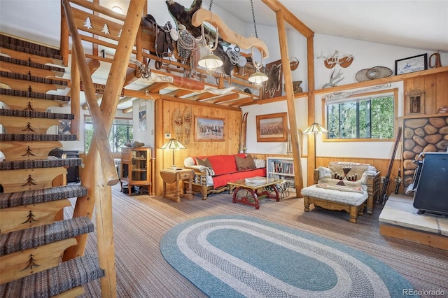 sitting room featuring lofted ceiling with beams, a healthy amount of sunlight, wooden walls, and carpet floors