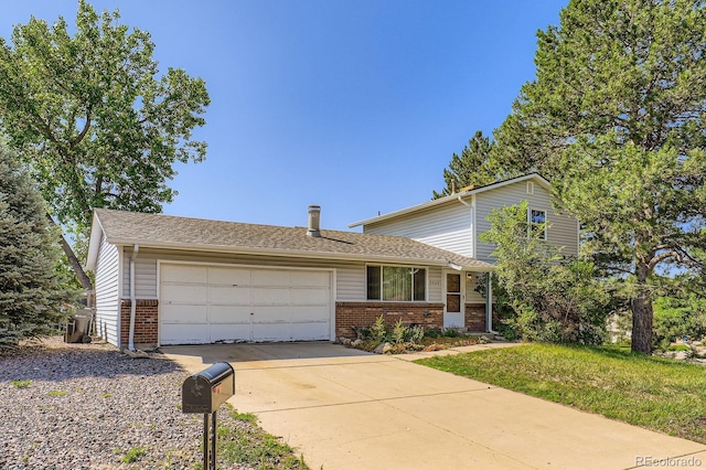 7542 Otis St, Arvada, CO 80003 - split level home with brick siding, a garage, and driveway