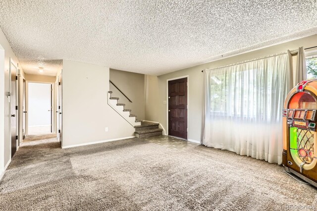 7542 Otis St, Arvada, CO 80003 - carpeted entryway featuring stairway and a textured ceiling