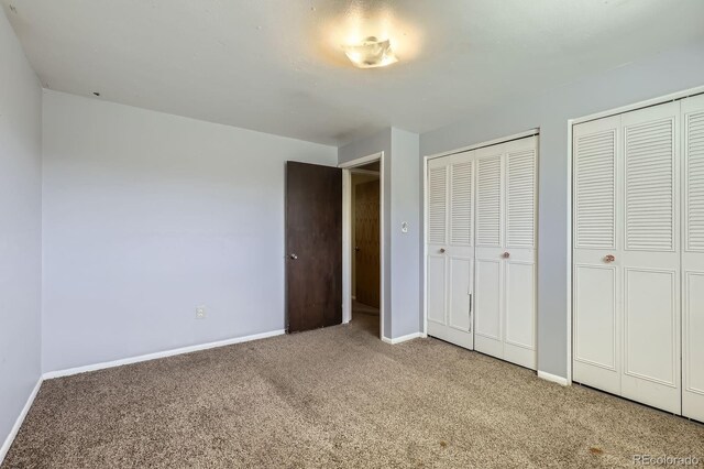 7542 Otis St, Arvada, CO 80003 - unfurnished bedroom with carpet flooring and two closets