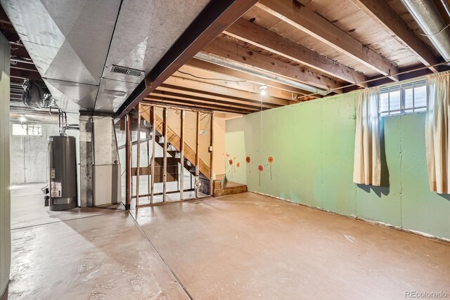 7542 Otis St, Arvada, CO 80003 - basement featuring water heater, stairway, and plenty of natural light