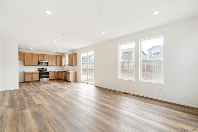 13402 E 110th Way, Commerce City, CO 80022 - kitchen featuring stainless steel appliances, light countertops, light wood-style floors, recessed lighting, and open floor plan