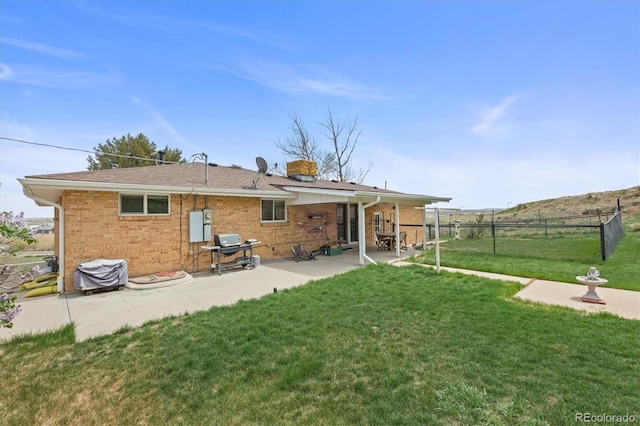12101 Riverdale Rd, Brighton, CO 80602 - back of house featuring a patio, brick siding, and a chimney
