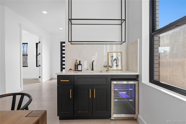 bar with backsplash, beverage cooler, and sink