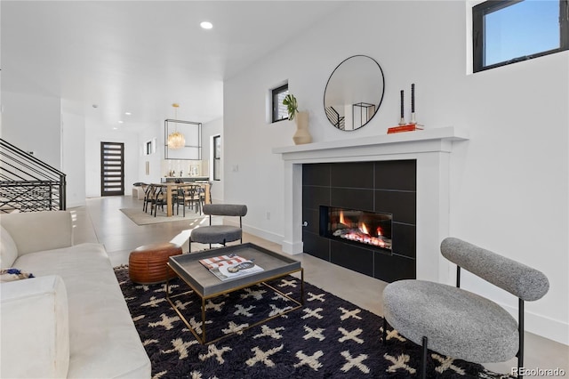 living room with concrete floors and a tile fireplace