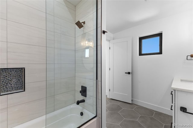 bathroom featuring vanity, tile patterned flooring, and tiled shower / bath