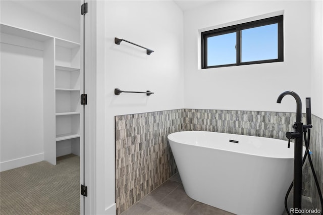 bathroom with tile patterned flooring and a bath