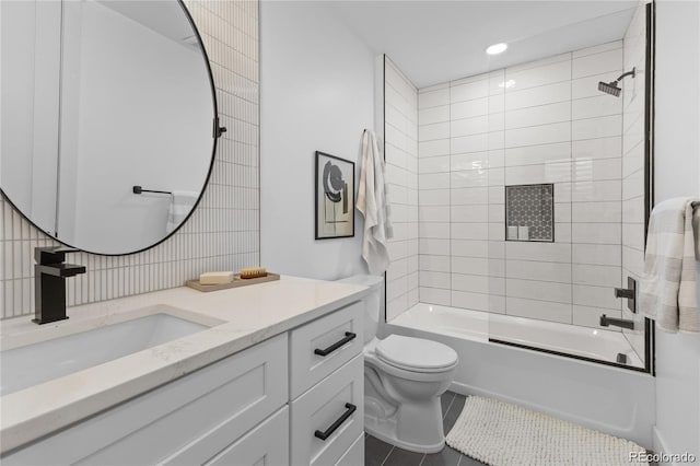 full bathroom featuring tile walls, vanity, tiled shower / bath combo, tile patterned flooring, and toilet