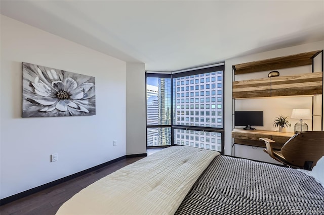 bedroom with dark hardwood / wood-style floors and a wall of windows