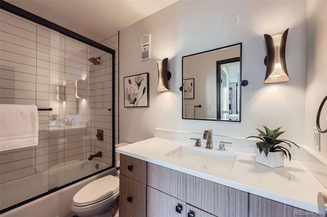 full bathroom featuring bath / shower combo with glass door, toilet, and vanity