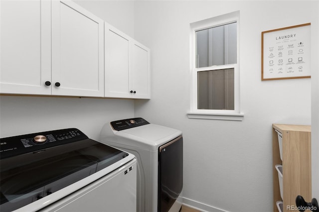 washroom with cabinets and washing machine and dryer