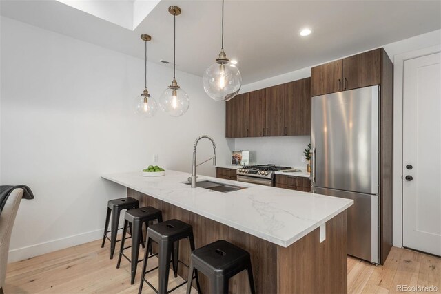 521 21st St, Golden, CO 80401 - kitchen featuring stainless steel appliances, a kitchen bar, a peninsula, light wood finished floors, and pendant lighting