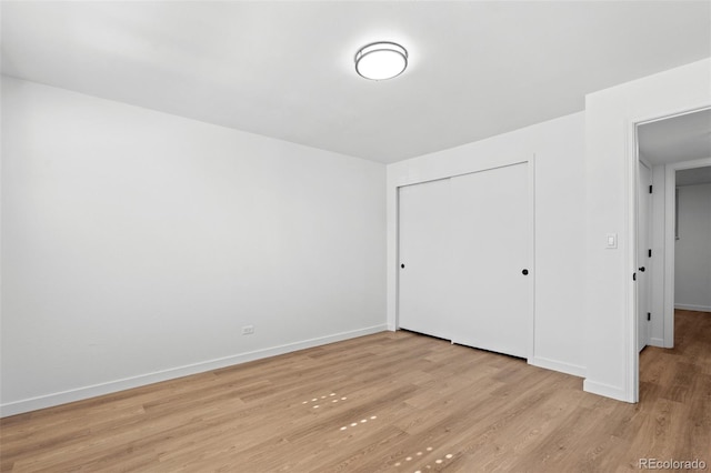 unfurnished bedroom with light hardwood / wood-style flooring and a closet