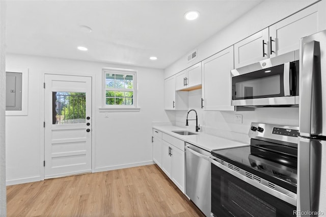 kitchen featuring sink, light hardwood / wood-style flooring, stainless steel appliances, and white cabinetry