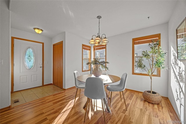 2226 Lily Dr, Loveland, CO 80537 - dining room featuring a chandelier, light wood-style flooring, and baseboards