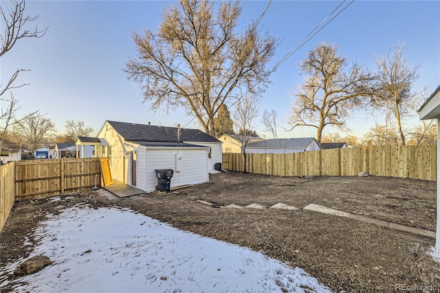 snowy yard featuring a shed