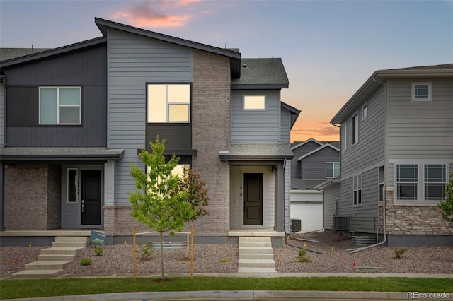 1418 Hudson Pl, Longmont, CO 80501 - contemporary house featuring an outdoor structure, brick siding, and roof with shingles