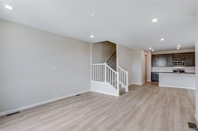 1418 Hudson Pl, Longmont, CO 80501 - unfurnished living room with light wood-style floors, stairs, and recessed lighting