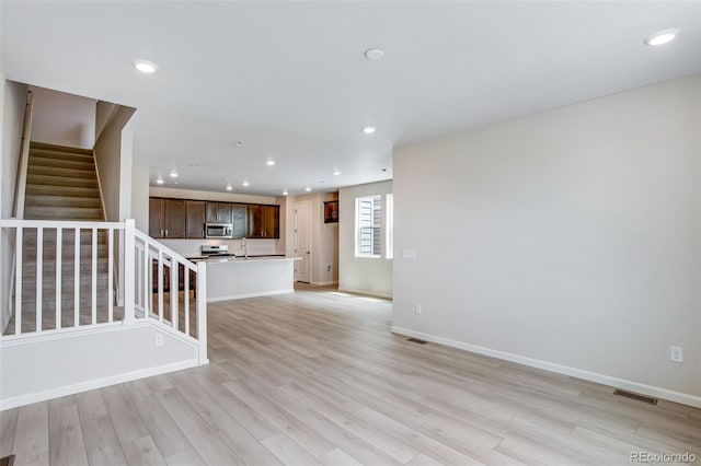 1418 Hudson Pl, Longmont, CO 80501 - unfurnished living room with stairway, light wood-style flooring, and recessed lighting