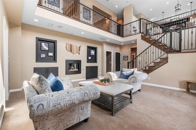 6303 Ellingwood Point Pl, Castle Rock, CO 80108 - carpeted living area featuring a towering ceiling, stairs, recessed lighting, and a glass covered fireplace