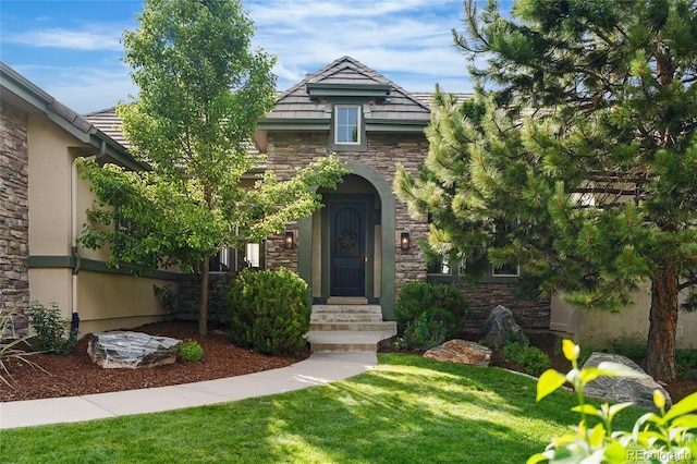 6303 Ellingwood Point Pl, Castle Rock, CO 80108 - view of front facade with stone siding, a front yard, and stucco siding