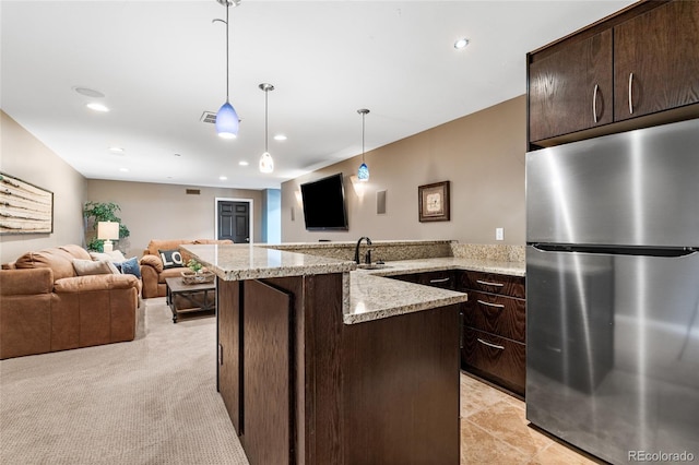 6303 Ellingwood Point Pl, Castle Rock, CO 80108 - kitchen featuring freestanding refrigerator, open floor plan, dark brown cabinetry, and recessed lighting