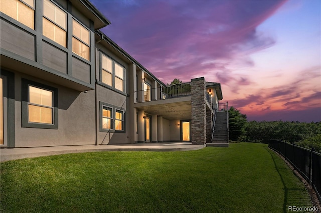 6303 Ellingwood Point Pl, Castle Rock, CO 80108 - back of house at dusk with a balcony, stucco siding, a patio area, and stairway