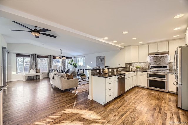 kitchen featuring white cabinetry, vaulted ceiling, stainless steel appliances, and kitchen peninsula