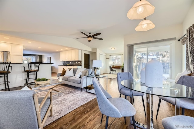 living room with ceiling fan, plenty of natural light, lofted ceiling, and dark hardwood / wood-style flooring