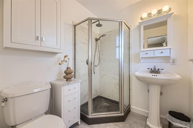 bathroom with tile patterned floors, toilet, and a shower with shower door