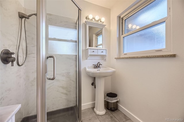 bathroom featuring a shower with door, a wealth of natural light, and tile patterned floors