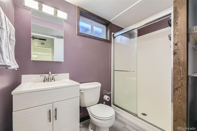 bathroom with hardwood / wood-style flooring, vanity, toilet, and an enclosed shower