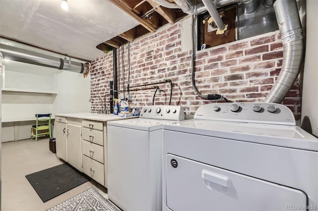 washroom featuring cabinets, sink, and washer and dryer