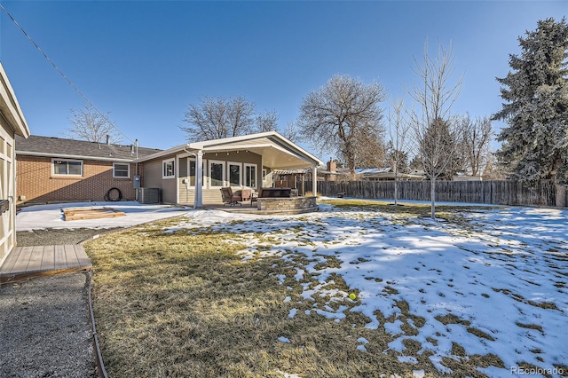 snowy yard featuring a patio and central AC