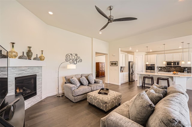 14521 Vancouver Pl, Parker, CO 80134 - living room with ceiling fan, vaulted ceiling, recessed lighting, dark wood-style flooring, and a tiled fireplace