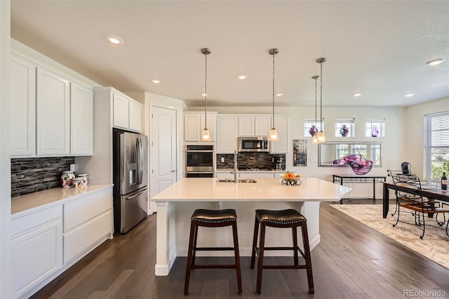 14521 Vancouver Pl, Parker, CO 80134 - kitchen featuring tasteful backsplash, appliances with stainless steel finishes, white cabinets, dark wood finished floors, and a sink