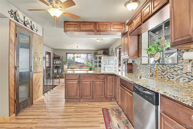 kitchen with sink, hanging light fixtures, light hardwood / wood-style flooring, dishwasher, and kitchen peninsula