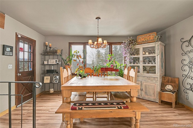 dining area featuring an inviting chandelier and light hardwood / wood-style floors