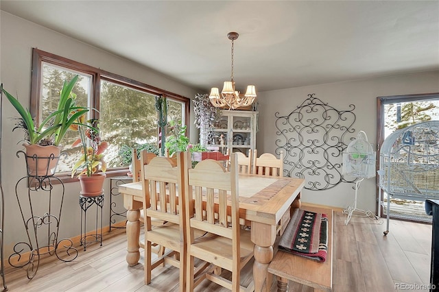 dining space featuring a chandelier and light wood-type flooring