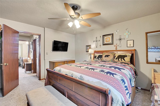 bedroom featuring ceiling fan, light colored carpet, and a textured ceiling