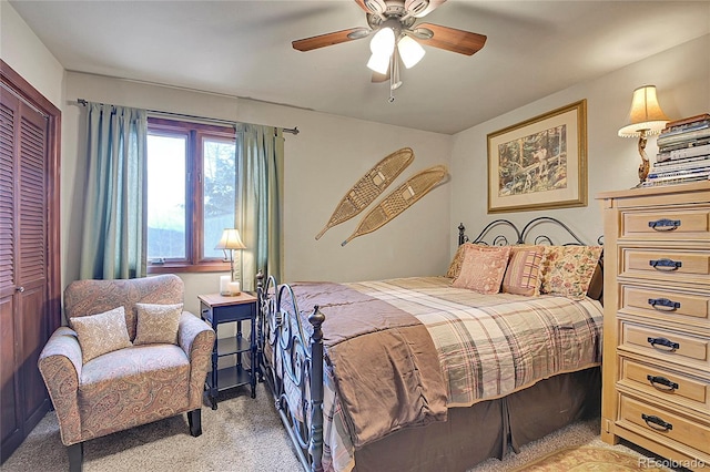 carpeted bedroom featuring ceiling fan and a closet