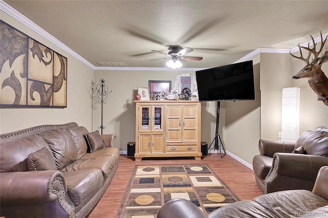 living room featuring ornamental molding, hardwood / wood-style floors, a textured ceiling, and ceiling fan