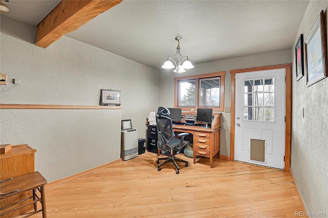 home office featuring a chandelier and light hardwood / wood-style flooring